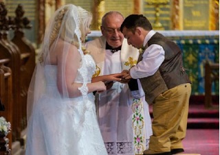 Chú rể trèo đứng trên bậc thang để hôn cô dâu trong đám cưới
