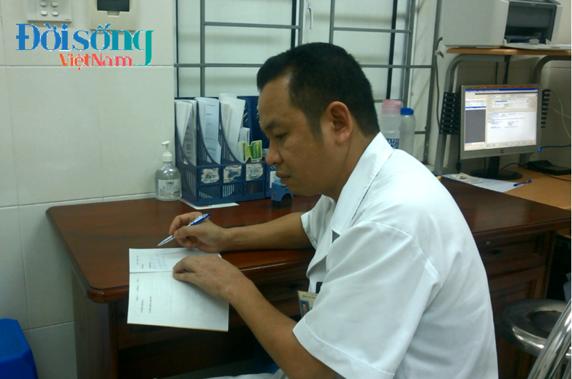 Bác sĩ Phạm Văn Hùng đang kê đơn thuốc cho người ăn xin 