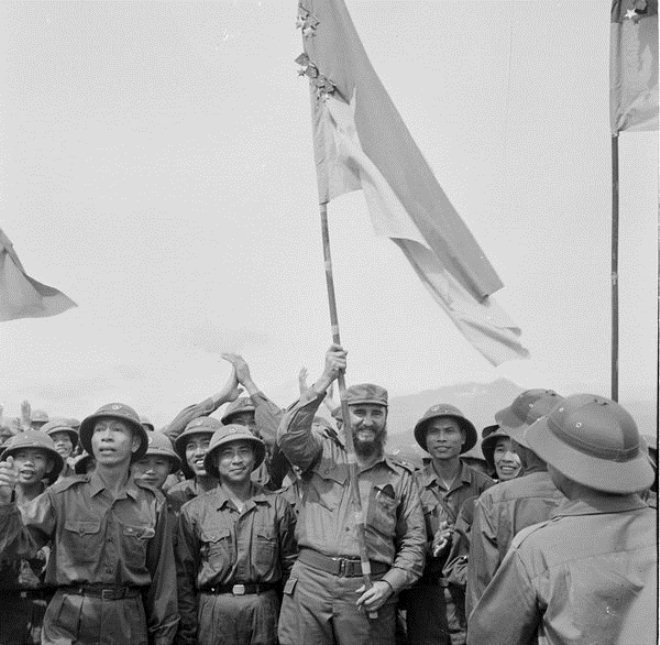 Fidel Castro phất cao lá cờ bách chiến, bách thắng lấp lánh huân chương của đoàn Khe Sanh, quân Giải phóng Huế - Ảnh: TTXVN
