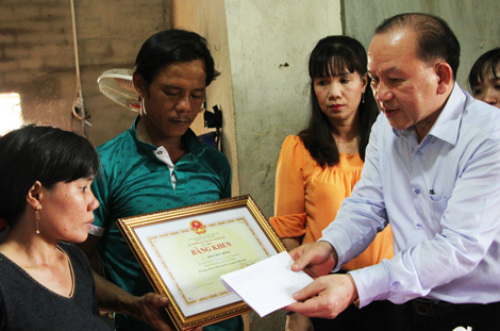 Ông Hà Hữu Phúc (phải) đại diện Bộ Giáo dục và Đào tạo trao bằng khen cho gia đình em Trần Đức Đông