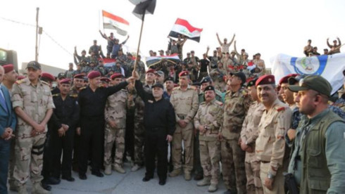 Thủ tướng Iraq Abadi vẫy quốc kỳ Iraq bên các binh sĩ Iraq tại Mosul. Ảnh: Twitter
