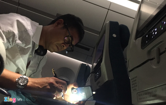  HLV Hữu Thắng dùng đèn flash từ chiếc điện thoại cặm cụi làm việc trên máy bay. Ảnh: Zing