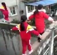 3 cô bé liều mạng đi trên bờ tường hẹp, cao gần 20 mét