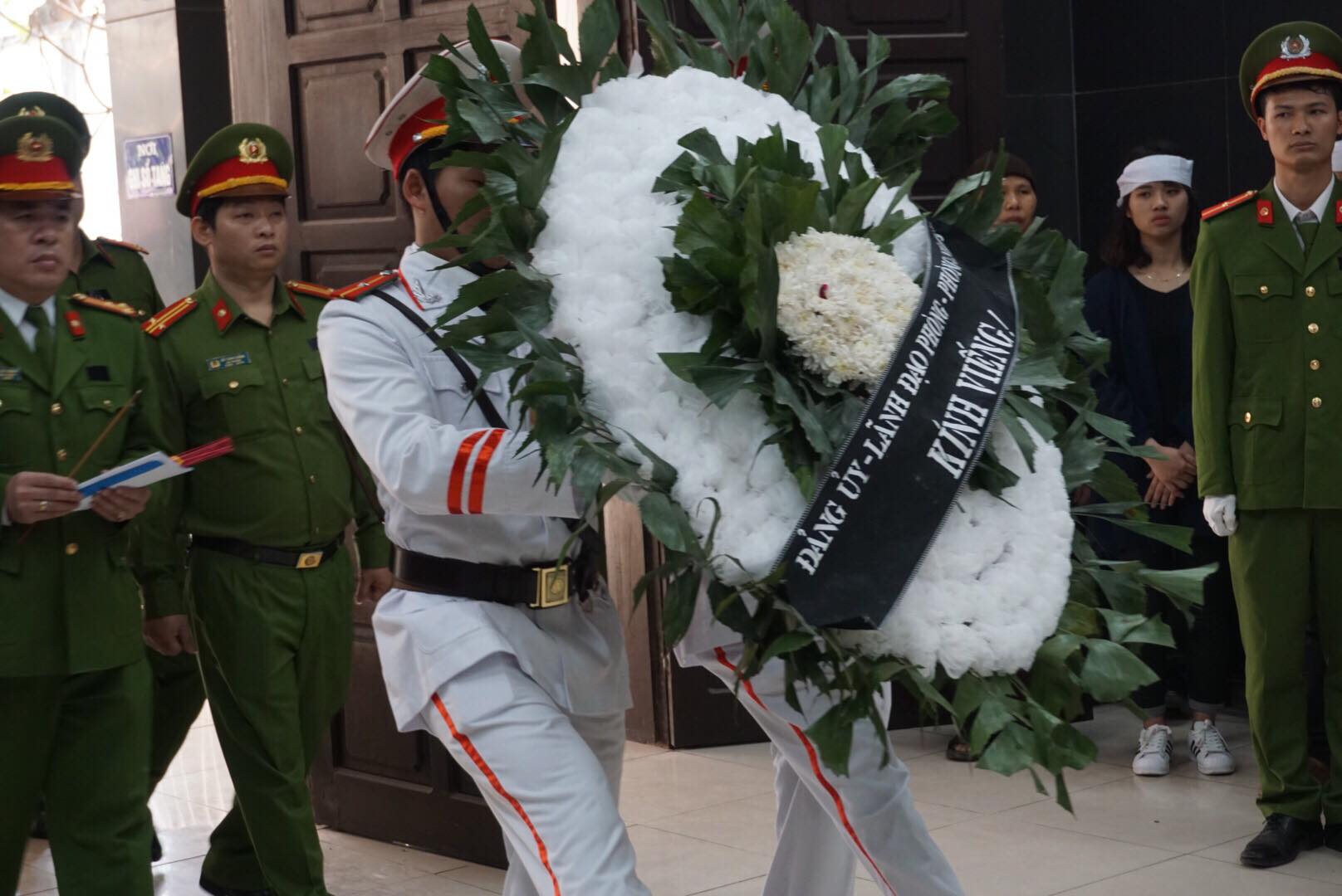 Những vòng hoa trắng được đưa vào lễ tang và xếp dọc hai bên đường