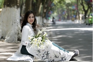 Nữ sinh báo chí duyên dáng trong tà áo dài với hoa loa kèn trên phố 