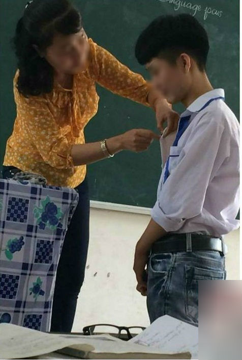 Cô giáo nhẹ nhàng khâu quần áo rách cho học sinh ngay trên lớp