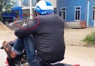 Nghệ An: Thanh niên điều khiển xe máy bằng chân, tay cầm điện thoại