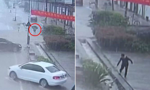 Bỏ ô tô trong cơn mưa bão đi cứu cậu bé bị nước cuốn trôi trong ống cống