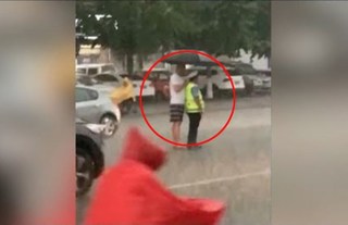 Clip: Chàng trai đội mưa cầm ô che cho nhân viên giao thông giữa đường