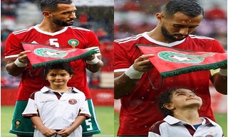Ấm áp khoảnh khắc đội trưởng tuyển Morocco dùng cờ hiệu che mưa cho bé gái trên sân cỏ