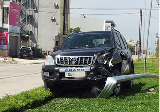 Toyota Land Cruiser Prado lao lên dải phân cách húc đổ cột đèn chiếu sáng