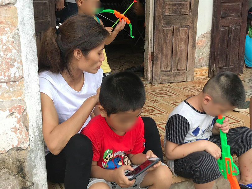 Chị Hương và 2 cháu bé ngồi trước cửa nhà