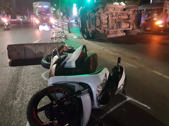 Xe của sở Ngoại vụ Tiền Giang tông giải phân cách văng vào xe máy bên đường