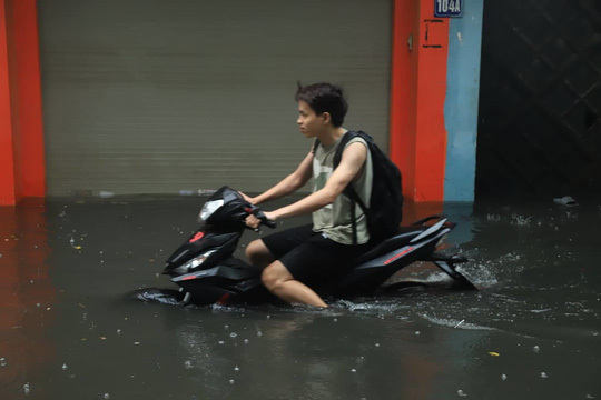 Xe máy lội bì bõm sau cơn mưa lớn vào sang nay tại Hà Nội.