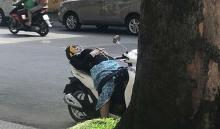 Cô gái ngủ ngon lành trên xe máy dựng giữa đường gây tranh cãi