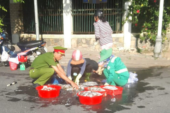 Xúc động hình ảnh công an và lao công giúp dân nhặt mẻ cá văng ở đường