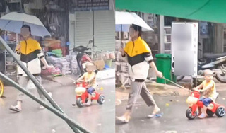  Thản nhiên che ô mặc em bé dầm mưa tầm tã, người phụ nữ bị chỉ trích vô cảm