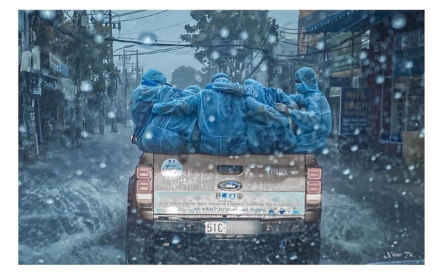 Đằng sau bức ảnh chiếc xe bán tải chở những áo xanh choàng vai dưới mưa tầm tã lay động triệu trái tim người Việt