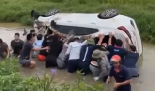 Hàng chục người hợp sức nâng ô tô lật ngửa dưới mương nước