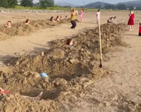Nhóm du khách đào hố như huyệt mộ trên bãi biển Cửa Lò để tắm cát gây xôn xao dư luận