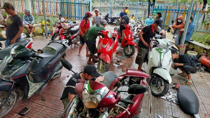 Xúc động hình ảnh nhóm thợ từ Quảng Nam ra Đà Nẵng sửa miễn phí hàng trăm xe máy cho dân vùng ngập